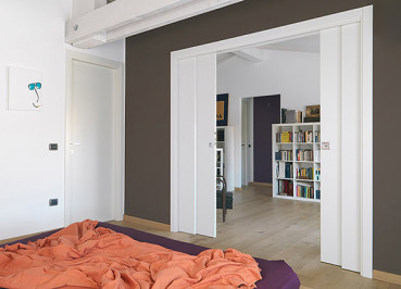 Preview: Schiebetürkasten TELESKOP zweiseitig 205 cm Trockenbau Preview: Vier Türblätter aus Holz in einem Eclisse TELESKOP Einbaukasten für in der Wand laufende Schiebetüren. Installiert in einer Trockbauwand im Schlafbereich.